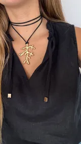 Collar con cordón marrón y dije dorado en forma de rama.