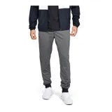 Pantalón deportivo tipo jogger para hombre, color gris jaspeado, con cintura elástica negra y cordón de ajuste. Presenta puños ajustados en los tobillos y un bolsillo lateral con cierre. Logo de Under Armour bordado en la pierna izquierda.