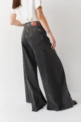 Pantalón de jean azul de tiro alto y corte wide leg súper amplio, con diseño de perneras ancha y terminación desmechada en el ruedo.