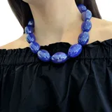 Collar corto de resina azul con cuentas ovaladas grandes y cierre de mosquetón dorado con cadena de alargue.