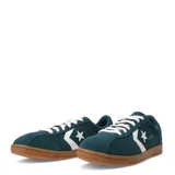 Championes Converse All Star Classic Trainer Suede, color verde oscuro, con capellada de gamuza, cordones blancos, suela de goma color caramelo y el logo clásico de la estrella y el chevron en blanco.