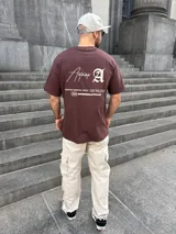 Remera marrón con estampa en la espalda con la palabra "Antwerp" y otros textos en color crema.