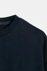 Camiseta corta de cuello redondo y manga corta, con diseño holgado y color negro.