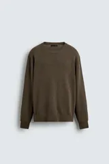 Jersey de punto con cuello redondo y manga larga, confeccionado en mezcla de algodón con textura de hilo torzal y acabados en rib.
