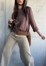 Blusa marrón chocolate de corte oversize, con mangas largas y detalles de encaje y botones forrados en el frente.