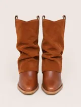 Botas de caña media combinadas, con puntera y base de cuero liso color suela y caña superior de gamuza color marrón oscuro con diseño holgado. Cuentan con taco bajo cuadrado.