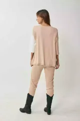 Remerón de manga tres cuartos con diseño tricolor en bloques diagonales: negro en el centro, beige claro en la parte superior izquierda y blanco en la manga derecha.