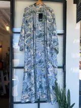 Kimono largo de tela estampada con motivos abstractos en tonos azules, verdes y beige. Diseño de manga ancha y corte recto, sin cierres.