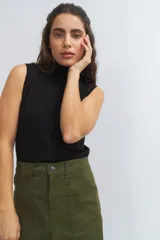 Chaleco negro de punto con cuello alto y sisas amplias.