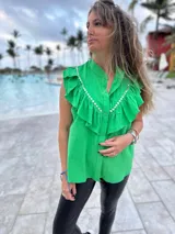 Camisa verde brillante de muselina con volados en el frente y tachas plateadas.