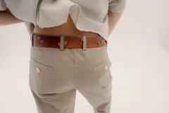 Cinturón de cuero marrón con hebilla negra y detalles metálicos en forma de rosas y rombos.