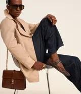 Buzo femenino modelo trench coat, confeccionado en poliéster con detalles acetinados. Posee cuello solapa, cierre delantero con 6 botones matizados y lazo con faixa pespontada.