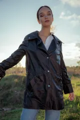 Chaqueta de cuero ovino italiano color negro, con cuello clásico, cierre frontal con botones a presión, bolsillos laterales con solapa y costuras en contraste color naranja.