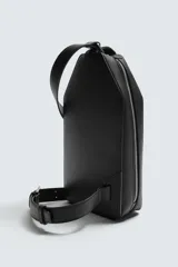 Bandolera vertical de diseño minimalista con acabado texturizado. Cuenta con compartimento principal con cierre de cremallera, bolsillo frontal con cierre y asa de hombro ajustable.