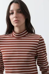 Polera de cuello alto con diseño de rayas horizontales en color azul marino sobre fondo blanco, confeccionada en tejido de punto con mangas largas.