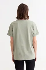Remera de algodón color verde oliva con cuello redondo, mangas cortas y estampa frontal con la frase 'LE SOLEIL EST MAGIQUE' en letras blancas.