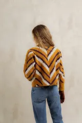 Sweater de punto jacquard con diseño de chevron en tonos celeste y marrón. Presenta cuello redondo, corte holgado y mangas largas con hombros abullonados.