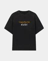 Remera oversize negra con efecto acid wash, cuello redondo y mangas cortas. Presenta un estampado frontal con la inscripción "Uruguay Run Club" en color amarillo y una secuencia de siluetas corriendo en gris.