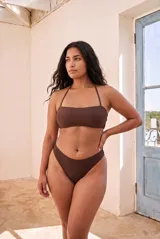 Conjunto de bikini marrón de dos piezas, compuesto por un top bandeau con tirantes finos al cuello y bombacha de corte clásico.