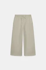 Pantalón de tiro alto con cintura elástica ajustable mediante cordón. Presenta un corte recto y holgado con bolsillos laterales y traseros.