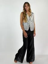 Pantalón de lino color beige, corte palazzo, con detalle de crochet en el lateral inferior.