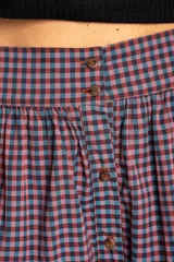 Falda midi de algodón con estampado de cuadros gingham en tonos rosa y azul marino. Tiene corte acampanado, cintura alta y botonadura frontal.