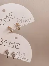 Par de aros pequeños, tipo argolla, dorados con un cristal engarzado.