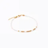Pulsera de cuentas pequeñas color blanco con detalles de cuentas doradas.
