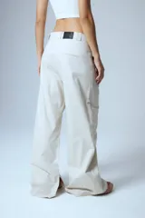 Pantalón de gabardina color crudo, estilo sastrero, de tiro bajo y corte recto. Presenta pinzas delanteras, presillas anchas, tajo interno en la botamanga y badana de PU en la cintura trasera.