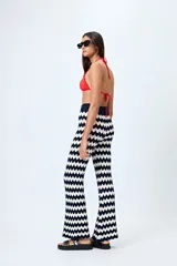 Pantalón tejido con motivo zigzag en blanco y negro, de corte flare y cintura elastizada.