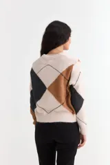 Sweater de punto con diseño de rombos en tonos gris, marrón y negro, con cuello en V y mangas largas.