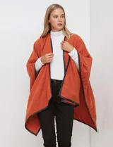 Ruana de tejido suave color azul oscuro, con vivos de ecocuero negro en los bordes.