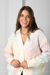 Saco tipo cardigan de punto con textura de panal, en tonos pastel multicolor. Presenta escote en V, cierre frontal con botones, mangas largas con puños acanalados y bolsillos delanteros.