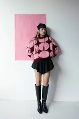 Buzo de tejido de punto color rosa con grandes círculos color borgoña.