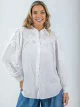 Camisa blanca de broderie con estilo boho y romántico, manga larga levemente abullonada.