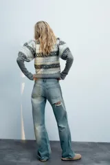 Jersey de punto con cuello redondo y mangas largas abullonadas, con diseño de jacquard geométrico en tonos grises, blancos y celestes.