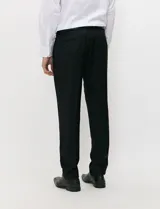 Traje de tres piezas color negro, compuesto por saco de dos botones, chaleco entallado y pantalón de corte slim, confeccionado en tejido de fantasía con spandex.
