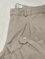 Pantalón de vestir azul marino, tipo bombacha de campo, con pliegues frontales y cintura con trabillas para cinturón.