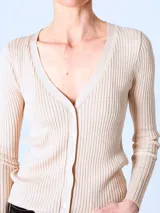 Cardigan de punto fino color beige, con escote en V y cierre frontal con botones.