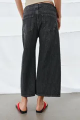 Jeans de tiro medio con diseño culotte y pierna ancha. Presenta un estampado de rayas verticales a contraste, cierre frontal con cremallera y botón, trabillas en la cintura y cinco bolsillos.