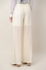 Pantalón palazzo tramado de color beige, con bolsillos laterales y cordón ajustable en la cintura.