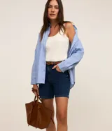 Short de jean azul oscuro, de talle medio con trabillas para cinturón, cierre de botón y cremallera, bolsillos delanteros y traseros, y costuras en contraste.