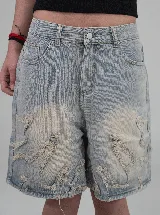 Short de jean estilo bermuda con diseño de llamas desflecadas en el frente. Presenta un lavado claro, corte recto y tiro bajo.