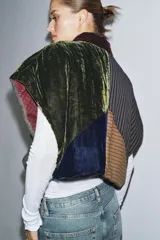 Chaqueta acolchada de diseño patchwork confeccionada en una combinación de tejidos que incluyen terciopelo, lana y satén a rayas. Presenta un corte holgado tipo kimono con forro interior estampado a contraste.