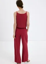 Pantalón de corte recto y tiro medio color bordó, confeccionado en lyocell, con trabillas en la cintura y bolsillos laterales.