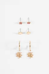 Set de tres pares de aros de metal plateado. Incluye un par de aros tipo stud con forma de flor con centro esmaltado en rojo, un par de aros tipo stud con forma de sol pequeño y un par de aros tipo argolla con dije colgante en forma de sol con diseño espiral.