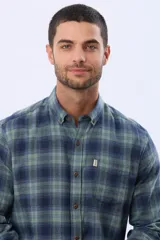 Camisa de viyela a cuadros en tonos marrón, azul marino y gris, con cuello clásico, cierre frontal con botones, mangas largas y un bolsillo en el pecho.