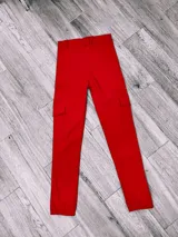 Pantalón cargo rojo de tela bengalina, con bolsillos laterales con solapa y tobillos ajustados.