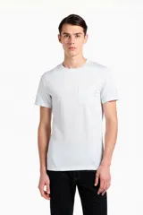 Remera de manga corta en color blanco, confeccionada en algodón, con cuello redondo a la base y bolsillo frontal aplicado en el pecho.