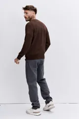 Sweater de punto de cuello redondo, con diseño jaspeado en tono marrón oscuro, de corte clásico y mangas largas con puños acanalados.